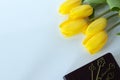 Bouquet of yellow tulips with ancient keys placed on closed holy bible book on white background, top view Royalty Free Stock Photo