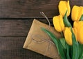 Bouquet of yellow tulips on dark rustic wooden background