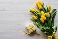 Bouquet of yellow tulips with gift box on white rustic wooden background with space for message. Holiday Royalty Free Stock Photo