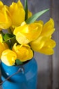 Bouquet of yellow tulips in vase on a wooden background Royalty Free Stock Photo