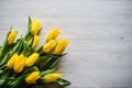 Bouquet of yellow tulips on white wooden background with space for message. Summer flowers concept. Spring Royalty Free Stock Photo