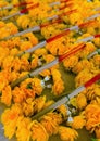 Bouquets of orange artificial flowers lie in rows.