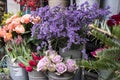 Bouquets of pink roses and red tulips, green hydrangea in pastel colors in large zinc buckets for sale in store