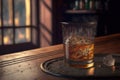 Bourbon or whisky glass on dark woody background, close up