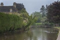 Stone footbridge across the River Windrush in Bourton-on-the-Water, also known as The Venice of the Cotswolds - Gloucestershire - Royalty Free Stock Photo