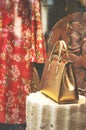 Boutique fashion display window with a dressed mannequin and golden bag in modern italian shop at the street of Florence city