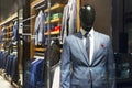 A boutique with men`s clothing on hangers and mannequins. Stylish shirts and suits Royalty Free Stock Photo