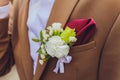 Boutonniere peonies flower on blue suit jacket of wedding groom close-up. Royalty Free Stock Photo