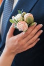 Boutonniere of pink and white peony in buttonhole of man& x27;s suit.