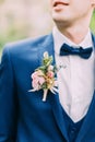 The boutonniere of roses on the jacket of the groom.