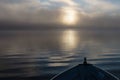 Bow of aluminum fishing boat at sunrise on foggy lake Royalty Free Stock Photo