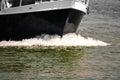 The bow of a black motorboat divides the water