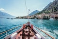 Boat tour: Boat bow, view over azure blue water, village and  mountain range. Lago di Garda, Italy Royalty Free Stock Photo