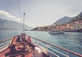 Boat tour: Boat bow, view over azure blue water, village and  mountain range. Lago di Garda, Italy Royalty Free Stock Photo