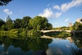 Bow bridge and big trees reflect in calming lake at Central Park Royalty Free Stock Photo