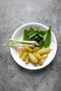 A bow containing a slice of turmeric leave, lemon grass and Averrhoa bilimbi