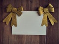 Bow Decorations with text space on white paper on a wooden background. Vintage greeting card. Holiday decorations and free space f