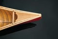 Bow nose of a canadian canoe, top view. Wood canoe boat on dark water