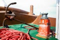 The bow of an old fishing boat which has a rusty anchor, a metal bollard and a red rope Royalty Free Stock Photo