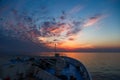 Bow of a passenger cruise ship moving in the open sea towards a stunning pink and orange sunset sky. View from the top. Royalty Free Stock Photo