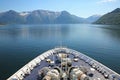 Bow of the ship as it cruises down the beautiful fjord with mountains & villages along the water, Hardangerfjord, Norway Royalty Free Stock Photo