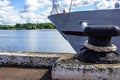 The bow of the ship and the mooring bollard overlook the river.