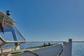 Bow of a steel excursion ship with white paint in front of a calm lake with blue sky and lots of copy space Royalty Free Stock Photo