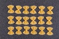 Bow Tie Pasta on grey background. Uncooked Farfalle. Italian national cuisine. Culinary background