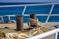 Bow of white yacht on background of blue sea.Thick anchor rope is wound around the bollards. Steel railings-fences.. Royalty Free Stock Photo