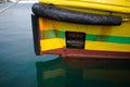 Bow of yellow boat with waterline, fairlead, raised anchor, rubber fender and draft marks on ship bow Royalty Free Stock Photo