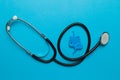 Bowel model with stethoscope on blue background. Irritable Bowel Syndrome
