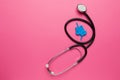 Bowel model with stethoscope on pink background. Irritable Bowel Syndrome. Copy space