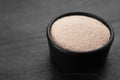 Bowl of active dry yeast on black table, closeup. Space for text Royalty Free Stock Photo