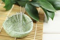 Bowl with acupuncture needles on white wooden table, closeup. Space for text Royalty Free Stock Photo