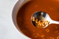 A bowl of alphabet tomato soup with the word lunch spelled out in the spoon.