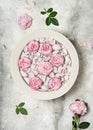 Bowl of aroma spa water with pink rose petals and flowers. Relaxation and harmony concept.