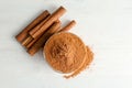 Bowl with aromatic cinnamon powder and sticks Royalty Free Stock Photo