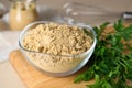 Bowl of aromatic mustard powder and parsley on wooden table, closeup Royalty Free Stock Photo