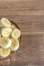 Bowl with banana slices on wooden background Royalty Free Stock Photo