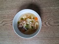 a bowl of beef broccoli soup in a white bowl on a wooden background Royalty Free Stock Photo