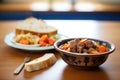 bowl of beef stew, a loaf of sourdough bread beside it