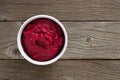 Bowl of beet hummus, above view on rustic wood Royalty Free Stock Photo