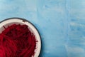 Bowl of beetroot cut into thin strips on blue painted wooden background. Vegetarian, organic, healthy food, diet, nutrition