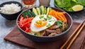 Bowl of bibimbap meal with meat, rice, vegetables and egg. Tasty Korean cuisine Royalty Free Stock Photo