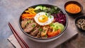 Bowl of bibimbap meal with meat, rice, vegetables and egg. Tasty Korean cuisine Royalty Free Stock Photo