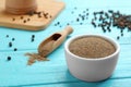 Bowl of black pepper powder and scoop on blue wooden table Royalty Free Stock Photo