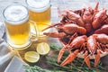 Bowl of boiled crayfish with two mugs of beer