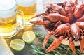 Bowl of boiled crayfish with two mugs of beer