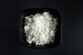 Bowl with boiled rice on black background. Asian food and bamboo chopsticks Royalty Free Stock Photo