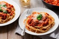 A bowl of Bolognese sauce, served on a bed of perfectly cooked pasta and garnished with a sprinkle of freshly grated Parmesan